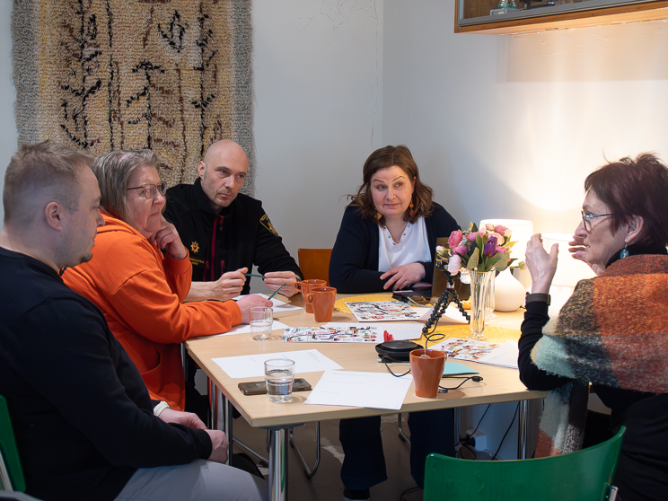 A group of five participants discussing around a table.