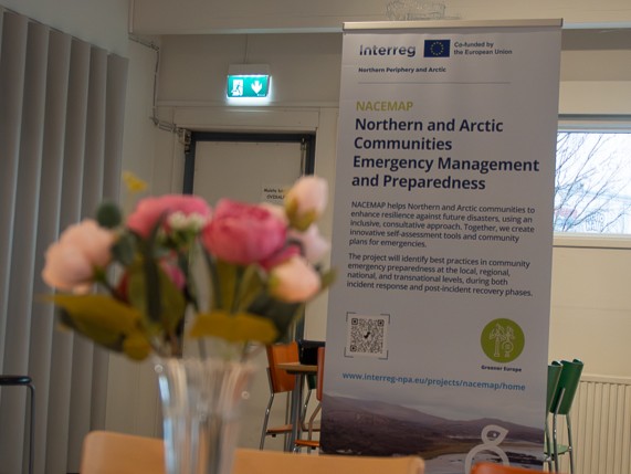 The NACEMAP roll-up displayed at the venue, roses in front of it on the table.