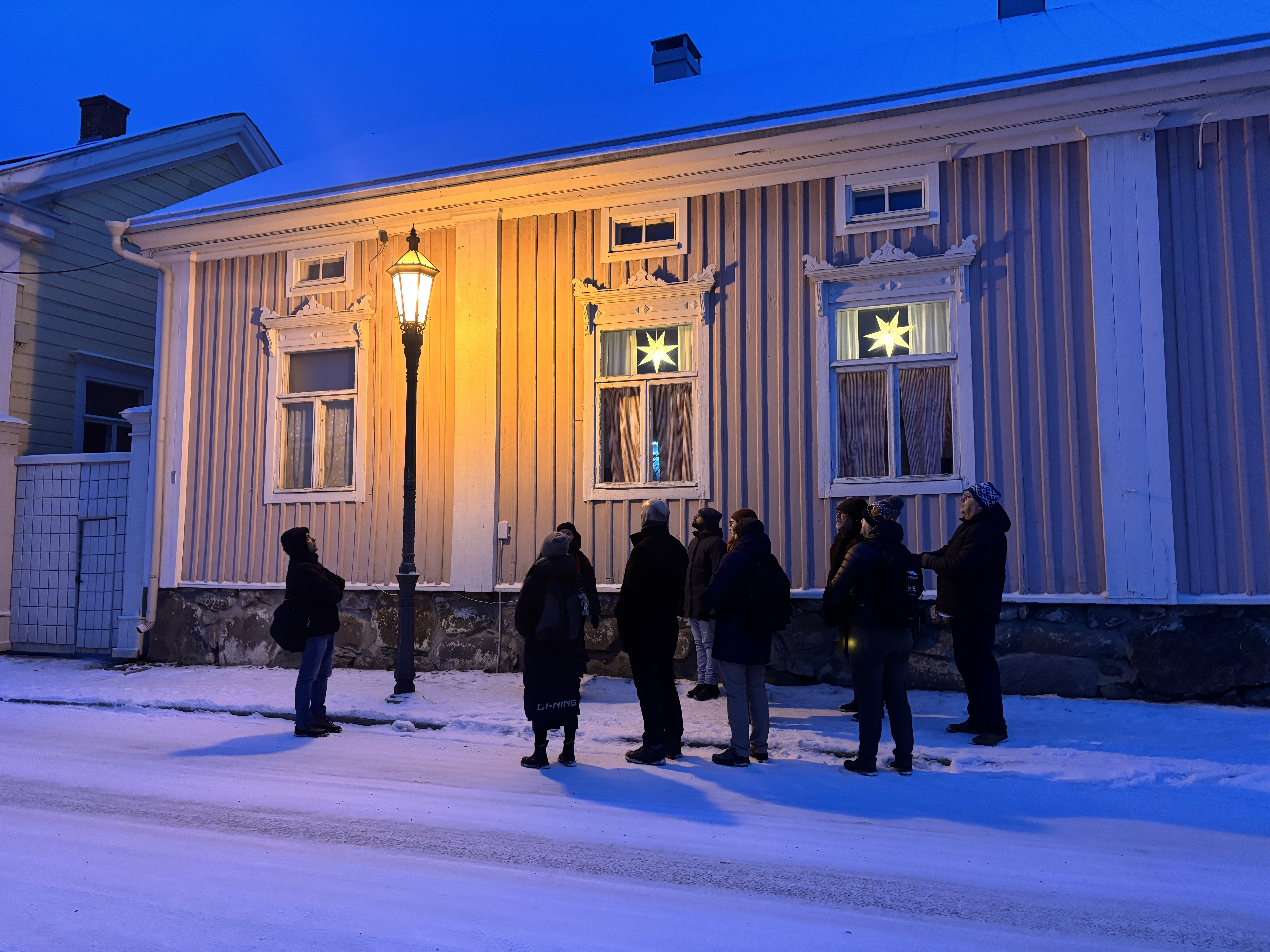 People standing outside of an old house at Kokkola, Finland in wintertime